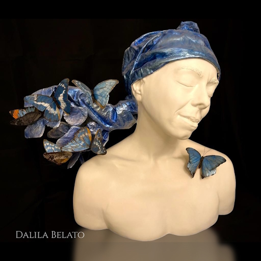 Dalila Belato Palermo artista - viso con farfalle - rendere visibile l'espressività del creato Le sue sculture sono realizzate attraverso tecniche miste e materiali ibridi, con l’uso di patine finali che a seconda dei casi le rendono simili al bronzo, al marmo e al ferro.